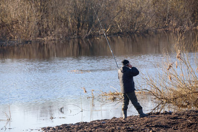 Side view of man fishing in lake