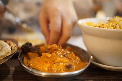 Close-up of hand holding food in bowl