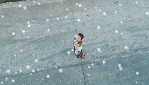 High angle view of boy standing on snow
