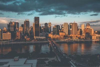 Modern cityscape against sky during sunset