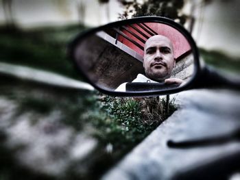 Portrait of mid adult man reflecting on side-view mirror