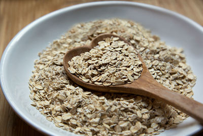 Close-up of breakfast cereal with heart shape wooden spoon on table