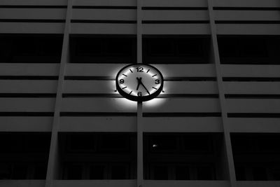 Low angle view of clock on illuminated building