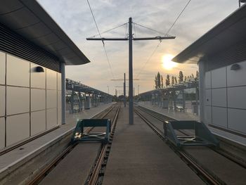 Railroad tracks against sky during sunset