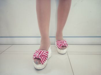 Low section of woman standing on tiled floor