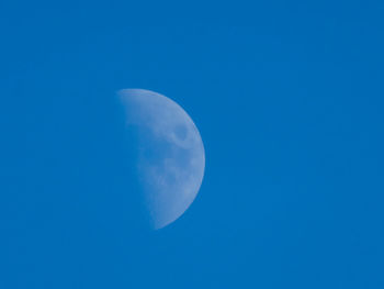 Low angle view of moon against blue sky