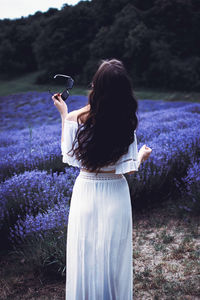Rear view of woman standing at lavender field