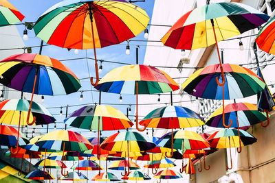 Low angle view of multi colored umbrellas hanging on building