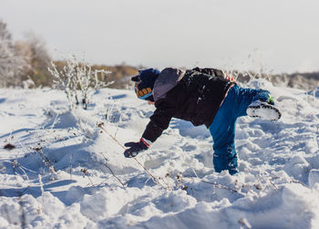Rear view of child on snow covered field