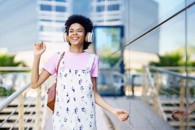 Portrait of young woman standing in city