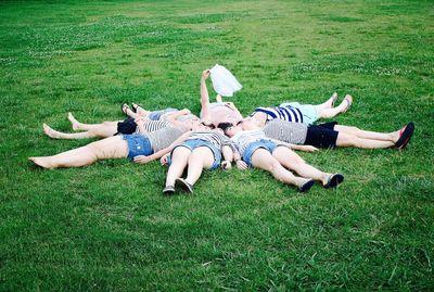 People relaxing on grassy field