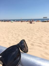 Close-up of shoes on beach against sky