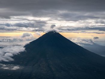 Low angle view of volcanic mountain against sky during sunset