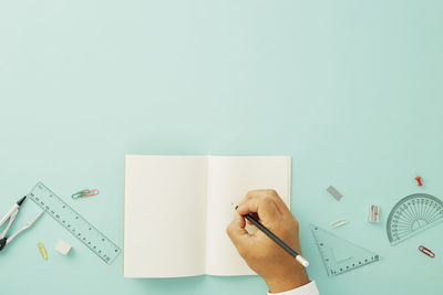 Midsection of person holding paper against white background