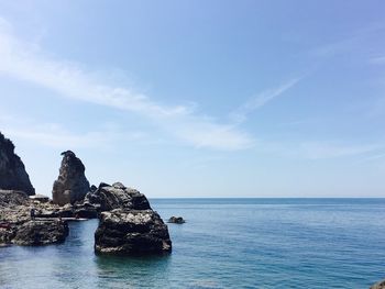 Scenic view of rock formation in sea against sky