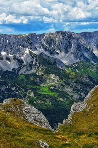 Scenic view of land and mountains against sky