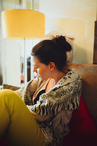 Young woman sitting on sofa at home