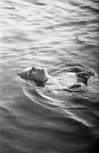 High angle view of woman floating on water at sea