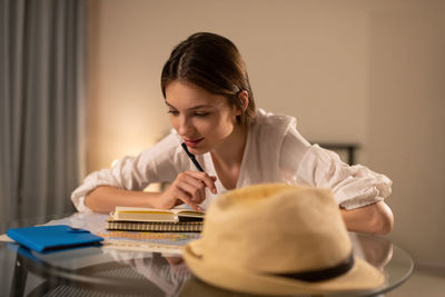 Portrait of a young woman sitting on table