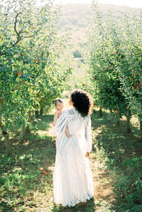 Rear view of woman standing on field