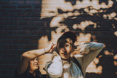 Portrait of mother and daughter against wall