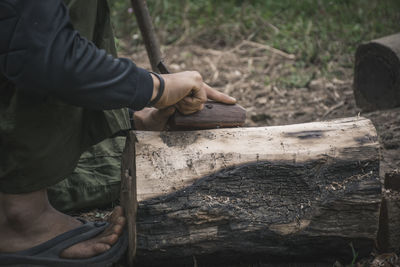 Low section of man carving wood