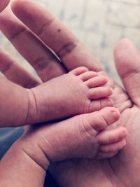 Close-up of baby feet in palm of hand