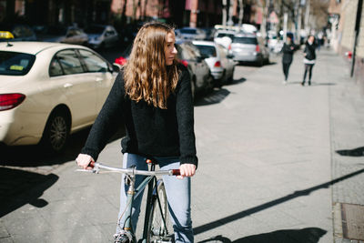 Man with bicycle on street in city
