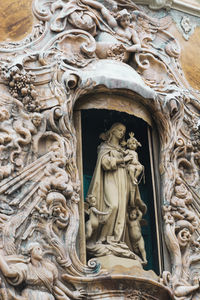 Low angle view of statue against historic building