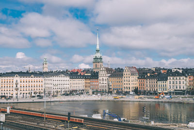 View of buildings in city against cloudy sky