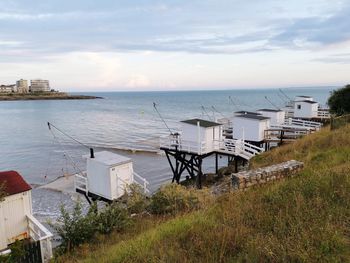 Scenic view of sea by buildings against sky