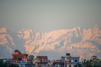 Buildings in city against clear sky