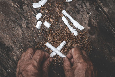 Cropped hands holding cigarettes outdoors