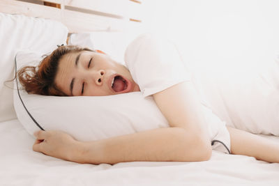 Portrait of baby girl lying on bed at home