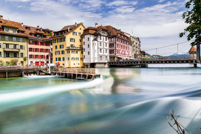 River by buildings against sky in city