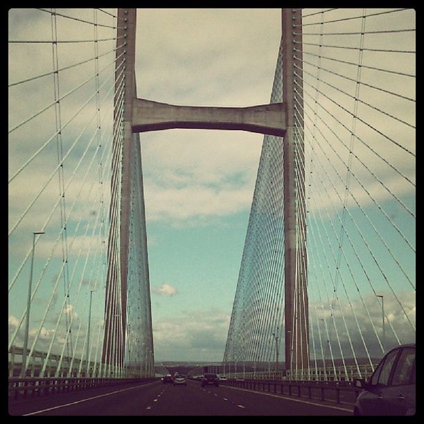 architecture, built structure, bridge - man made structure, sky, connection, transportation, building exterior, engineering, modern, city, cloud - sky, bridge, low angle view, the way forward, diminishing perspective, suspension bridge, cable-stayed bridge, cloud, road, cloudy