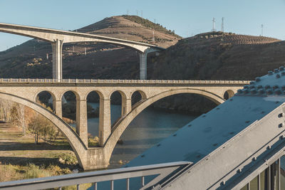 Arch bridge over river against sky