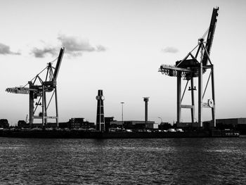 Cranes at construction site against sky