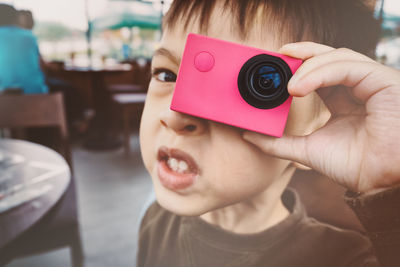 Close-up portrait of boy photographing with wearable camera
