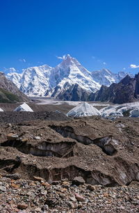 Scenic view of snowcapped mountains against blue sky