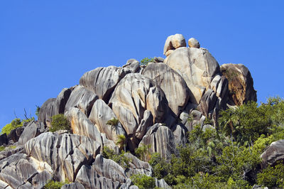 View of rocks against clear blue sky