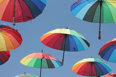 Low angle view of umbrellas hanging against sky