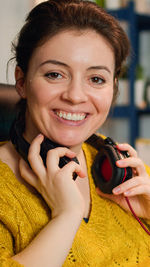 Portrait of a smiling young woman holding camera