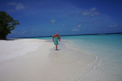 Rear view of two people standing on beach