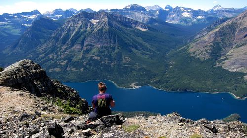 Man sitting on rock looking at mountains