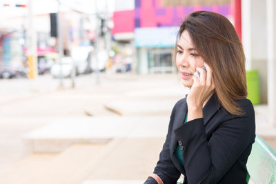Mid adult woman using mobile phone outdoors