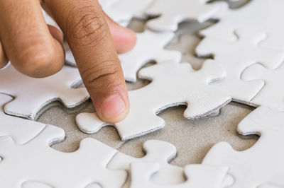 Cropped hand of child playing puzzle