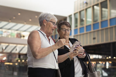 Senior female friends using cell phone