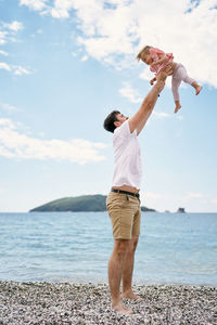 Full length of man standing at beach against sky