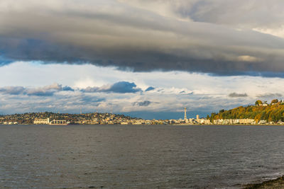 Scenic view of sea by buildings against sky